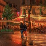 Zwei sich umarmende Menschen überqueren bei Abendlicht einen Zebrastreifen