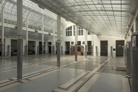 Heller lichtdurchfluteter Raum mit Säulen und Glasdach.