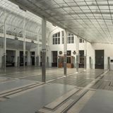 Heller lichtdurchfluteter Raum mit Säulen und Glasdach.