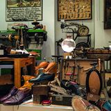 Nähmaschine, Bilder von Schuhen, auf dem Tisch alte Schuhe.