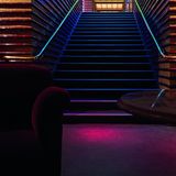 Bunt beleuchtete Treppe mit buntem Glas, es ist sehr dunkel.