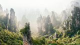 Als wollten sie durch das Licht schreiten, wachen steinerne Säulen über den Wald des chinesischen Nationalparks Zhangjiajie. Legenden erzählen, es seien die Soldaten des Herrschers Xiang Wang Tianzi, der sich gegen die chinesische Zentralmacht auflehnte. Die Formation entstand, indem Wasser das Gestein um die harten Quarzsäulen herum abtrug