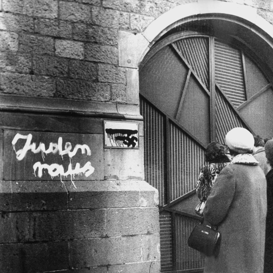 Eine Gruppe betrachtet im Dezember 1959 die mit antisemitischen Schmierereien geschändete Kölner Synagoge