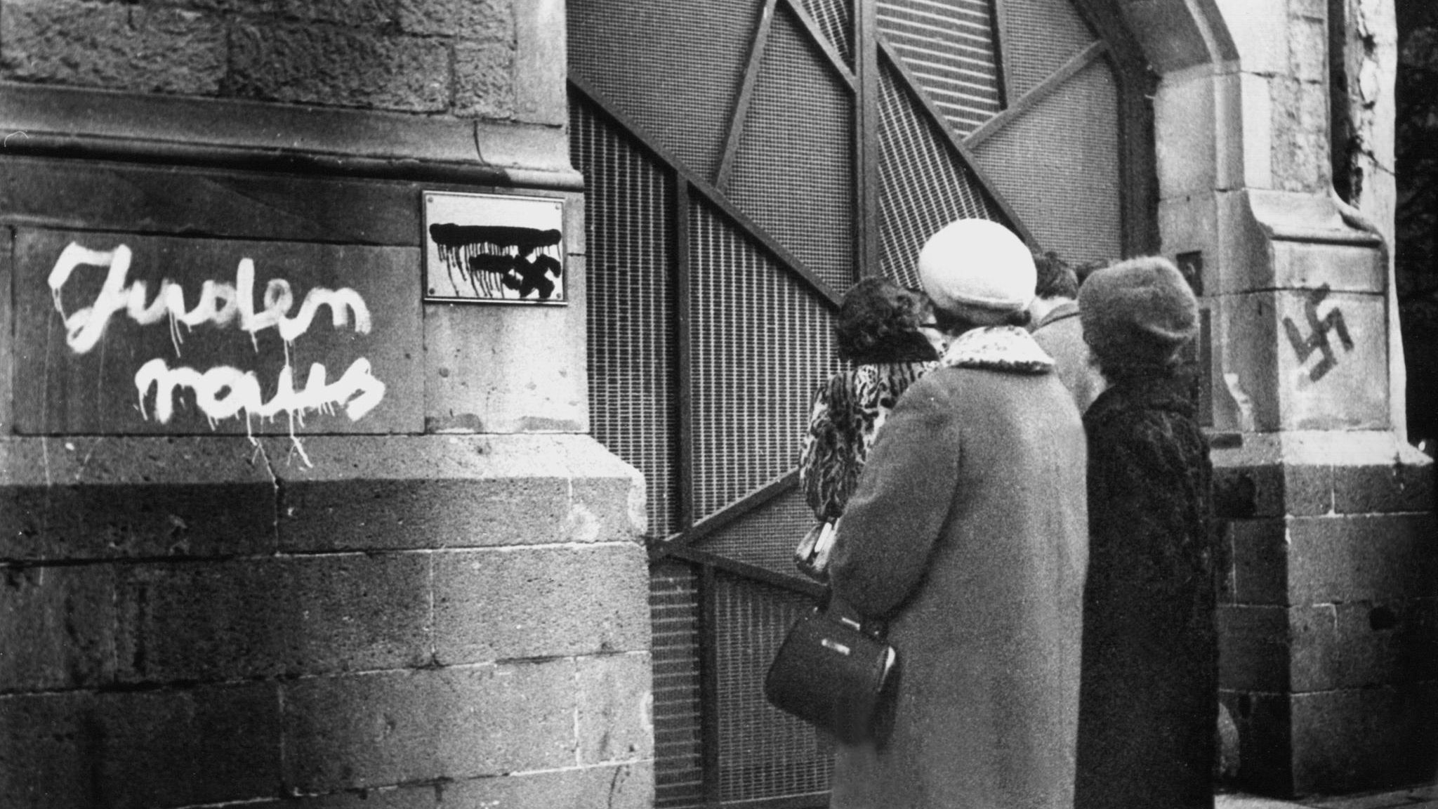 Eine Gruppe betrachtet im Dezember 1959 die mit antisemitischen Schmierereien geschändete Kölner Synagoge