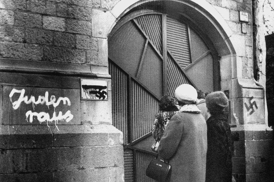 Eine Gruppe betrachtet im Dezember 1959 die mit antisemitischen Schmierereien geschändete Kölner Synagoge