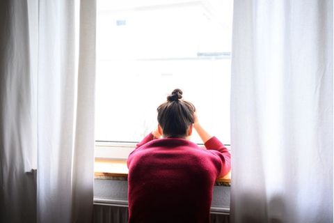 Ein Frau sitzt vor einem Fenster