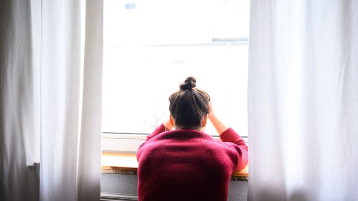 Ein Frau sitzt vor einem Fenster Ein Frau sitzt vor einem Fenster