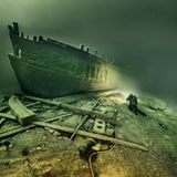 Eine Schiffswand unter Wasser im Licht eines Tauchers