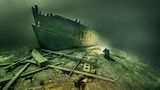 Eine Schiffswand unter Wasser im Licht eines Tauchers