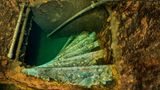 Sechs grün schimmernde schmale Stufen einer Wendeltreppe von oben gesehen