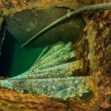 Sechs grün schimmernde schmale Stufen einer Wendeltreppe von oben gesehen