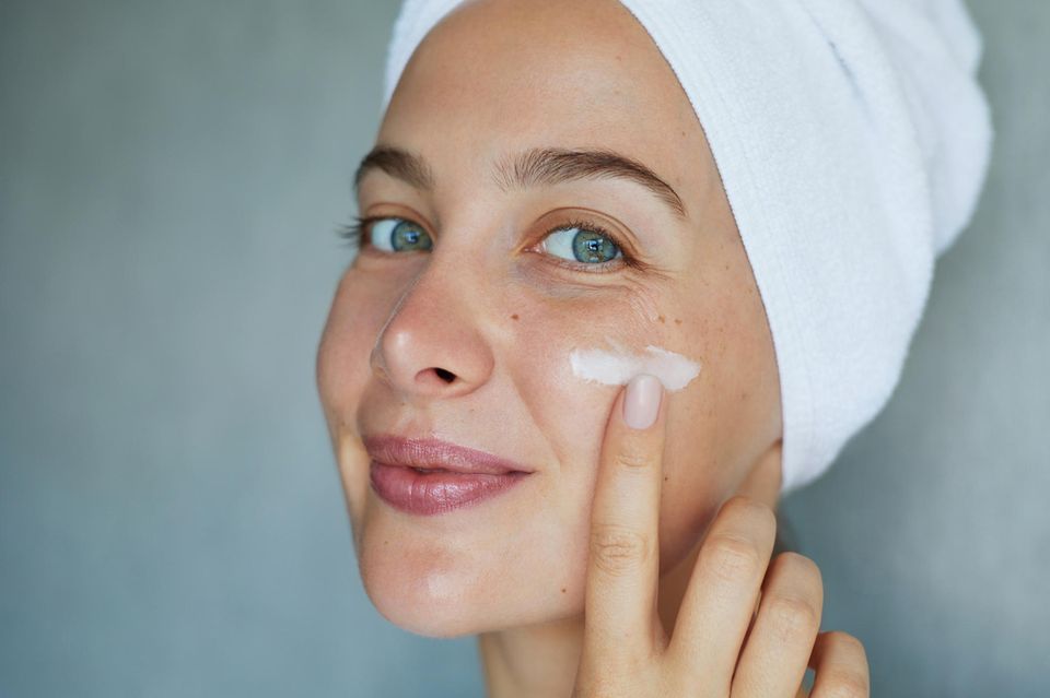 Naturkosmetik Adventskalender: Eine Frau probiert eine Gesichtscreme auf ihrer Wange aus