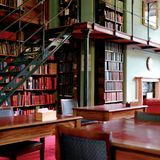 Tische, eine Treppe fürhrt auf eine Galerie, viele, viele Bücherregale