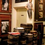 Mehrere Stapel mit alten Filmrollen in Blechbüchsen, an der Wand alte Filmbilder unter anderem James Dean.