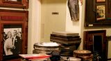 Cineastische Zeitreise: Cinema Museum Mehrere Stapel mit alten Filmrollen in Blechbüchsen, an der Wand alte Filmbilder unter anderem James Dean.