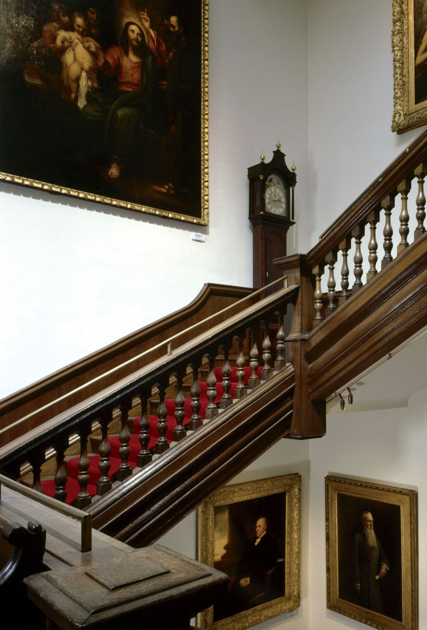 Kunst für Kinder: das Foundling Museum Treppe aus Holz mit historischer Standuhr und altem, großem Ölgemälde.