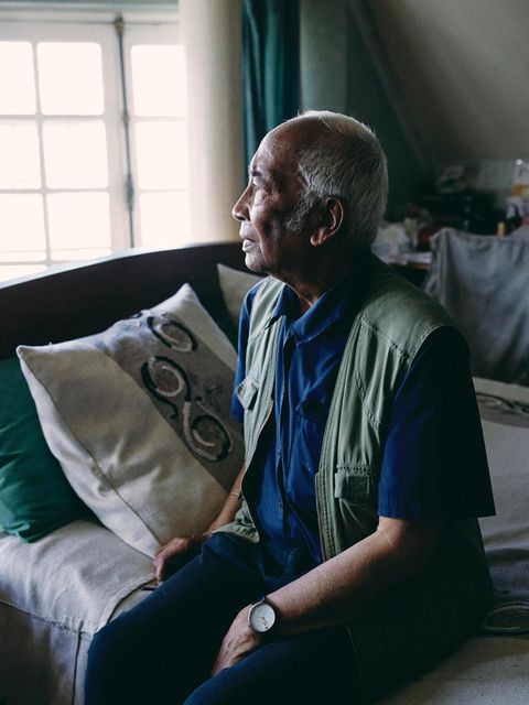 Tonton Jean Paul Randriambelomo sitzt im Schlafzimmer auf seinem Bett