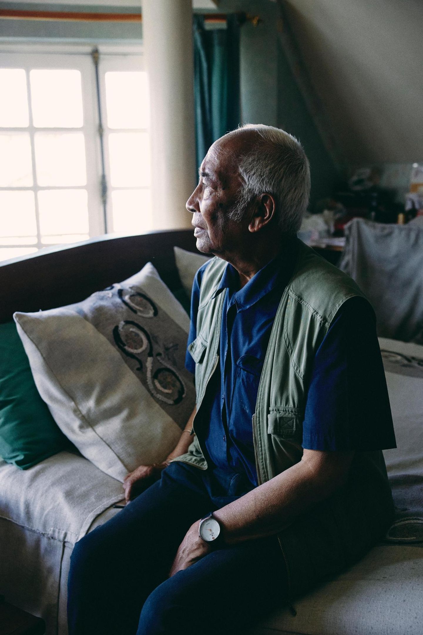 Tonton Jean Paul Randriambelomo sitzt im Schlafzimmer auf seinem Bett