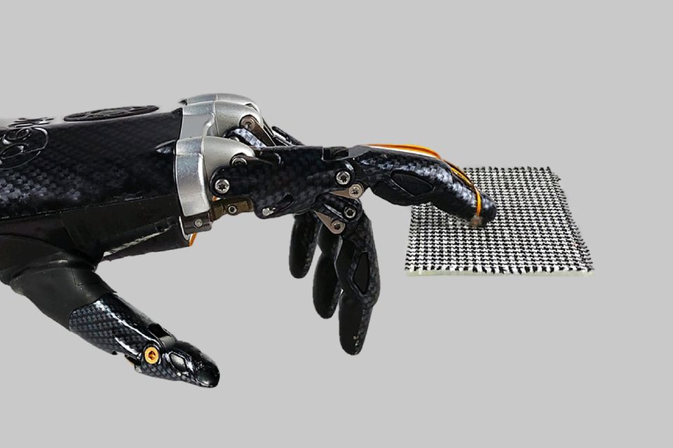 Roboterhand streicht über gemusterten Stoff