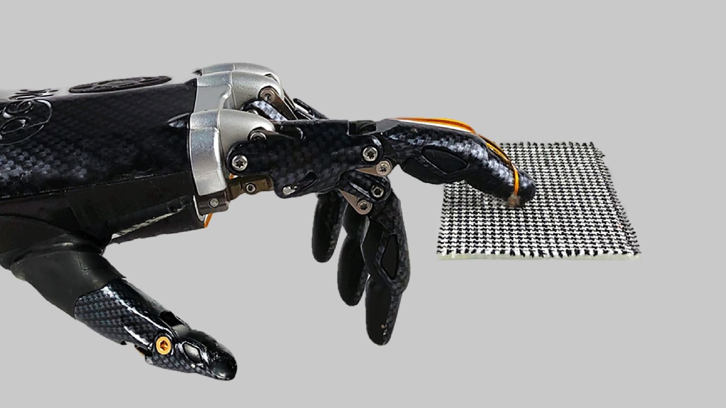 Roboterhand streicht über gemusterten Stoff