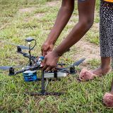 Studierende mit Drohne auf Feld