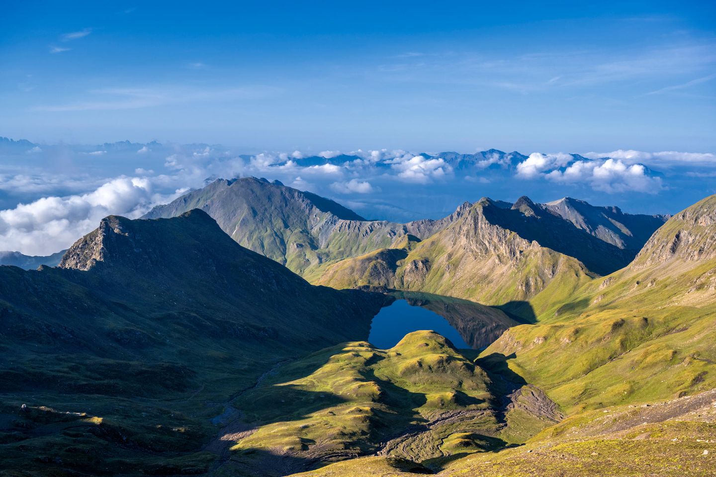 Hochgenuss: Wilder See Vals Kahles felsiges Hochgebirge, in der Senke liegt ein See. Blick geht weit in die Wolken.