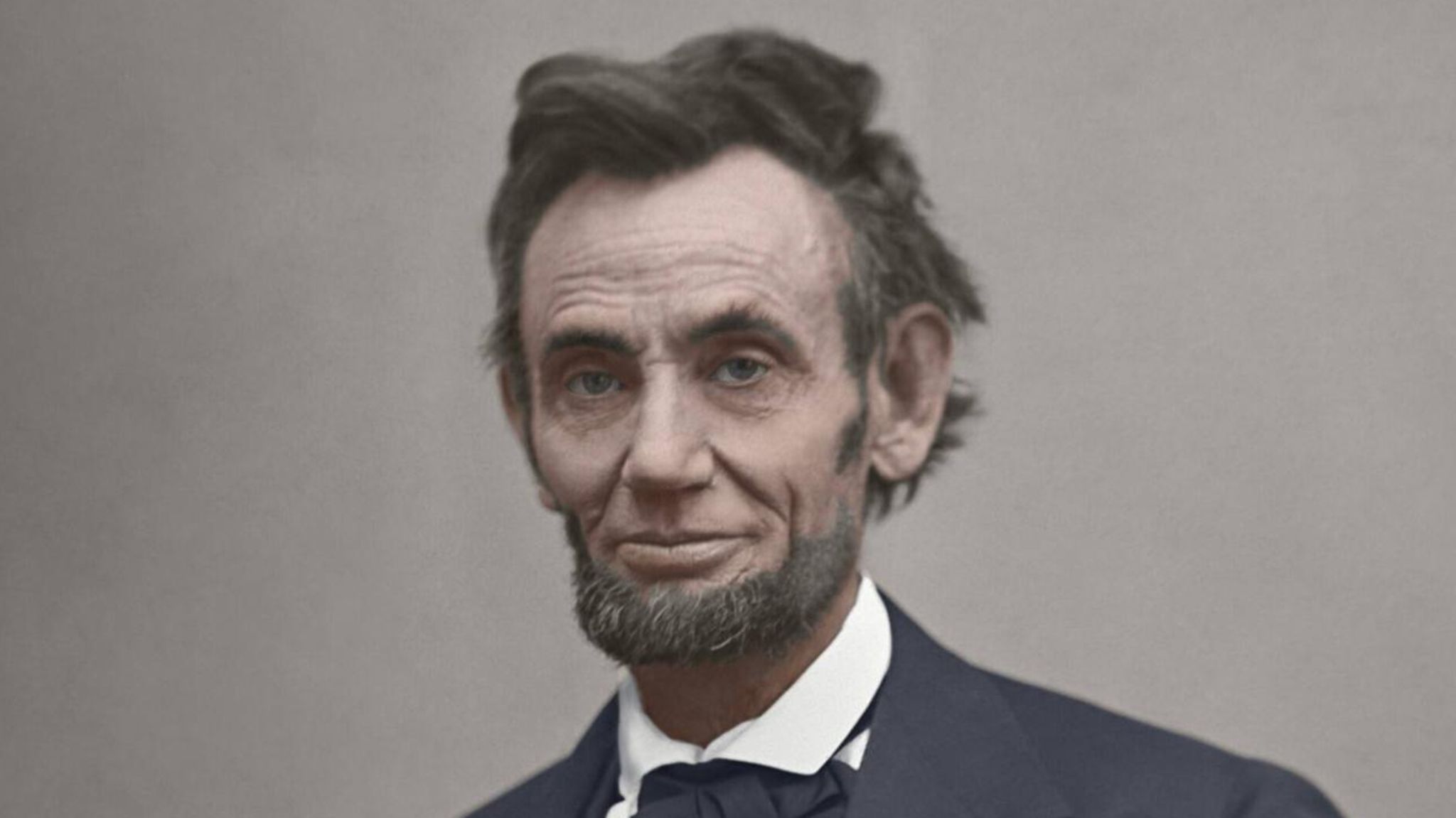 US-Präsident Abraham Lincoln sitzt im Anzug an einem Tisch