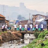 Menschen tragen Eimer über eine Brücke