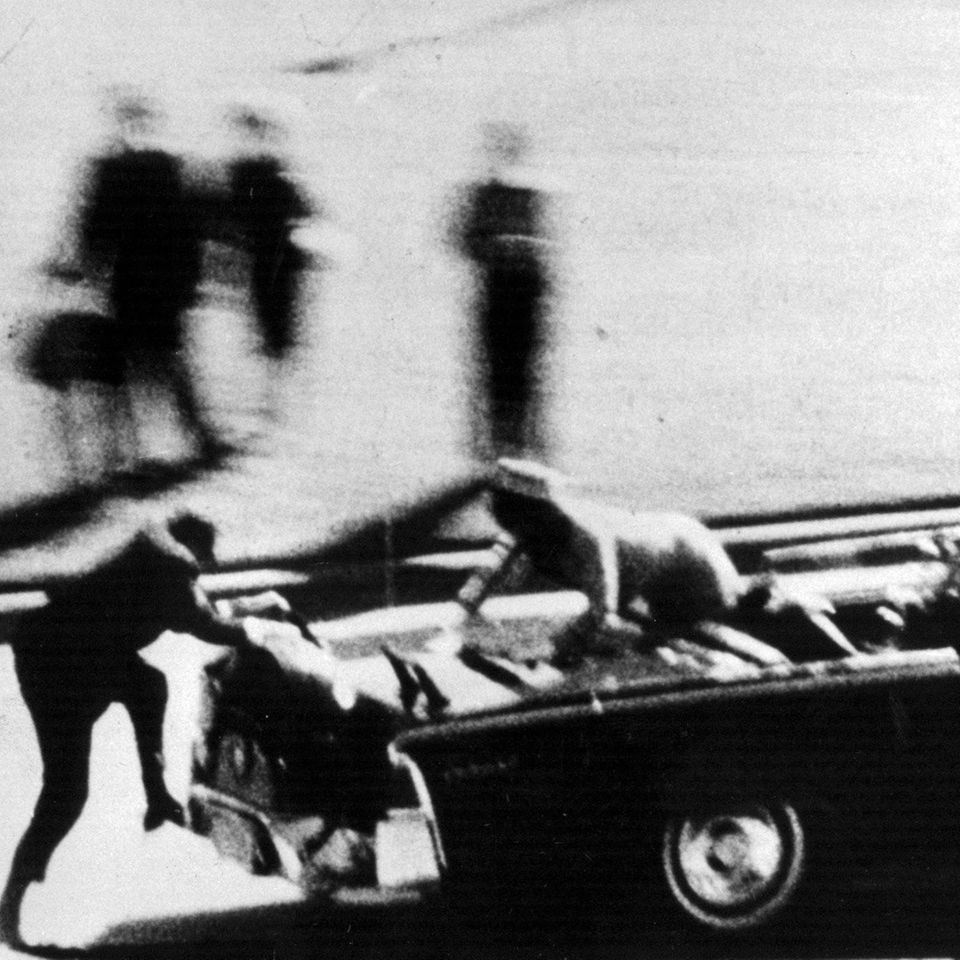 Die Frau des gerade angeschossenen US-Präsidenten John F. Kennedy klettert in Panik auf das Heck der Staatslimousine, sw-Foto