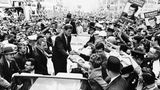 John F. Kennedy , stehend in einem offenen Auto, umringt von Anhängern mit Wahl-Plakaten; sw-Foto