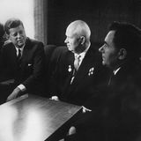 Kennedy und Chruschtschow an einem eckichen Couchtisch; sw-Foto