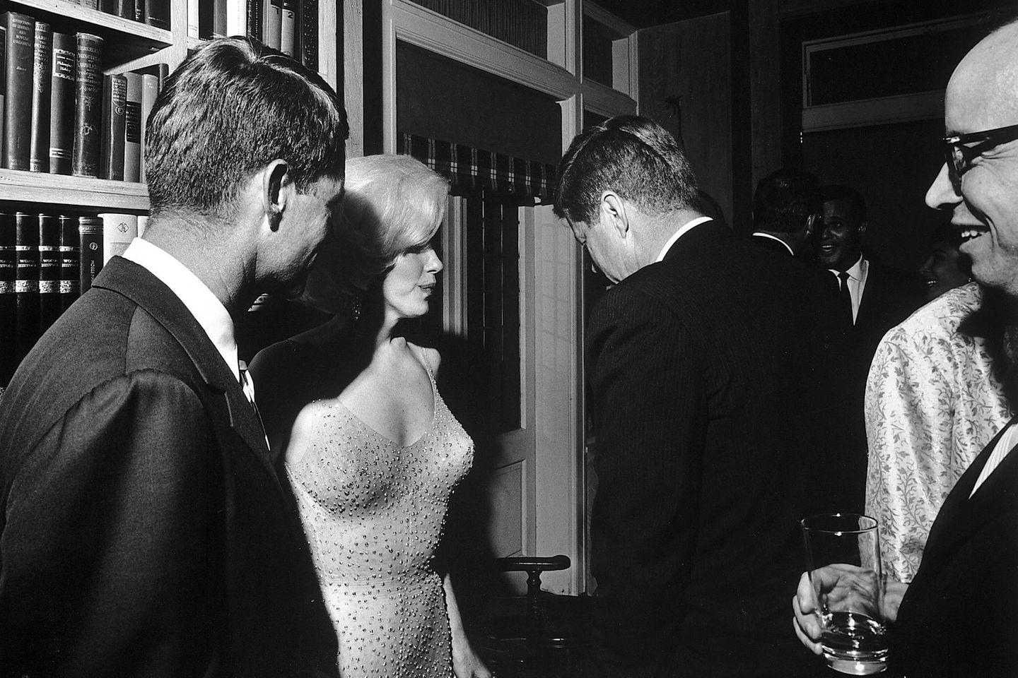 "Happy Birthday, Mr. President" Marilyn Monroe in einem hautengen Kleid, Kennedy und andere stehen vor einer Bücherwand zusammen; sw-Foto