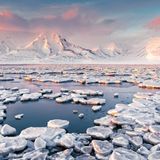 Runde Eisplatten treiben wie Seerosen auf dem arktischen Gewässer der Bucht von Adventdalen. Sie liegt unweit der Kleinstadt Longyearbyen, die Spitzbergens Hauptsiedlung ist – und noch dazu eine der nördlichsten Ortschaften der Welt