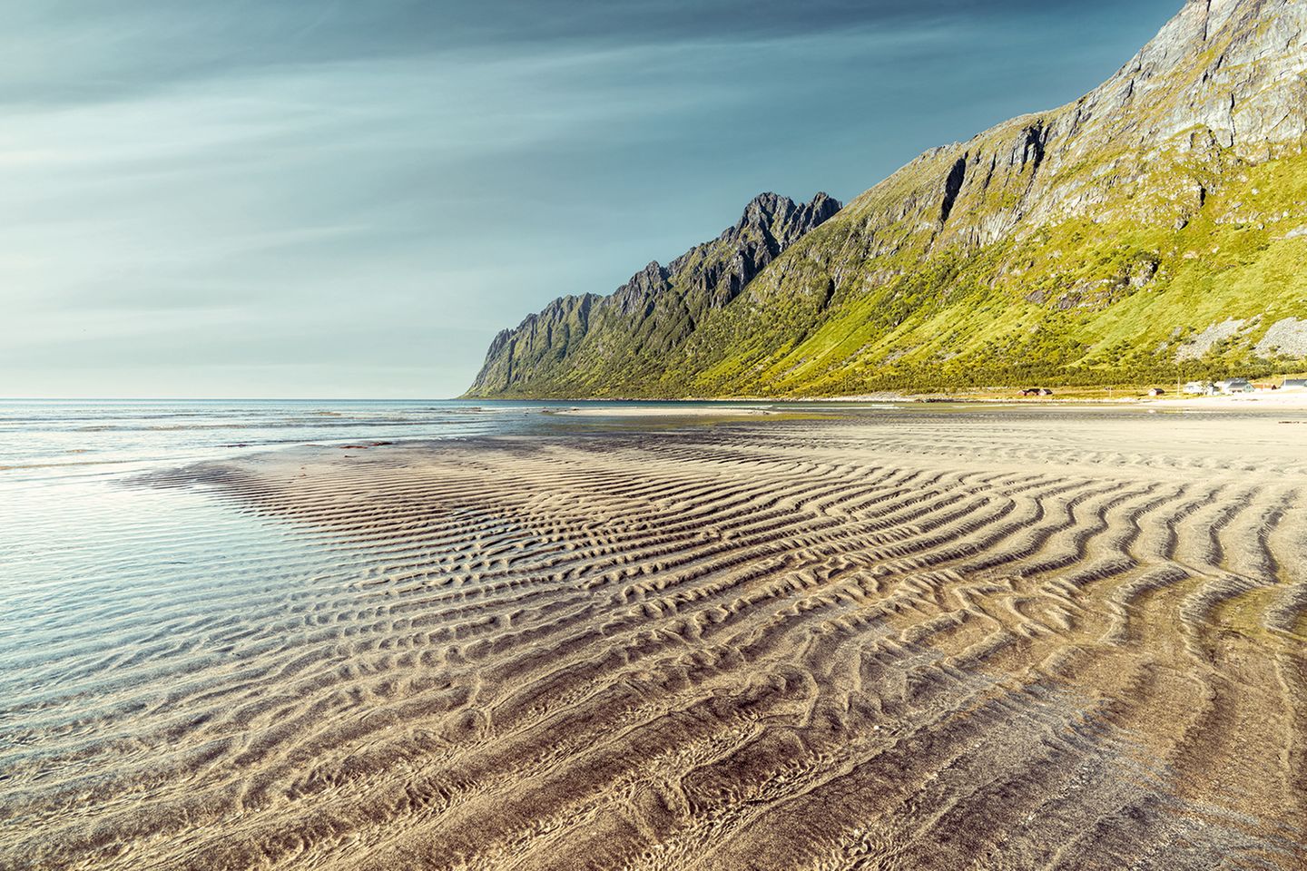 Am Ersfjord-Strand sorgt die Brandung dafür, dass die Wellen auch jenseits des Spülsaumes weitergehen. Umgeben von hohen, steilen Gipfeln entsteht hier eine skandinavische Karibikkulisse. Sie liegt direkt an der beliebten Landschaftsroute 862 auf der Insel Senja