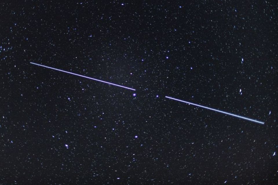 Zwei "Starlink"-Satelliten sind als Lichtstreifen am Nachthimmel zu sehen. Foto: Patrick Pleul/dpa-Zentralbild/dpa