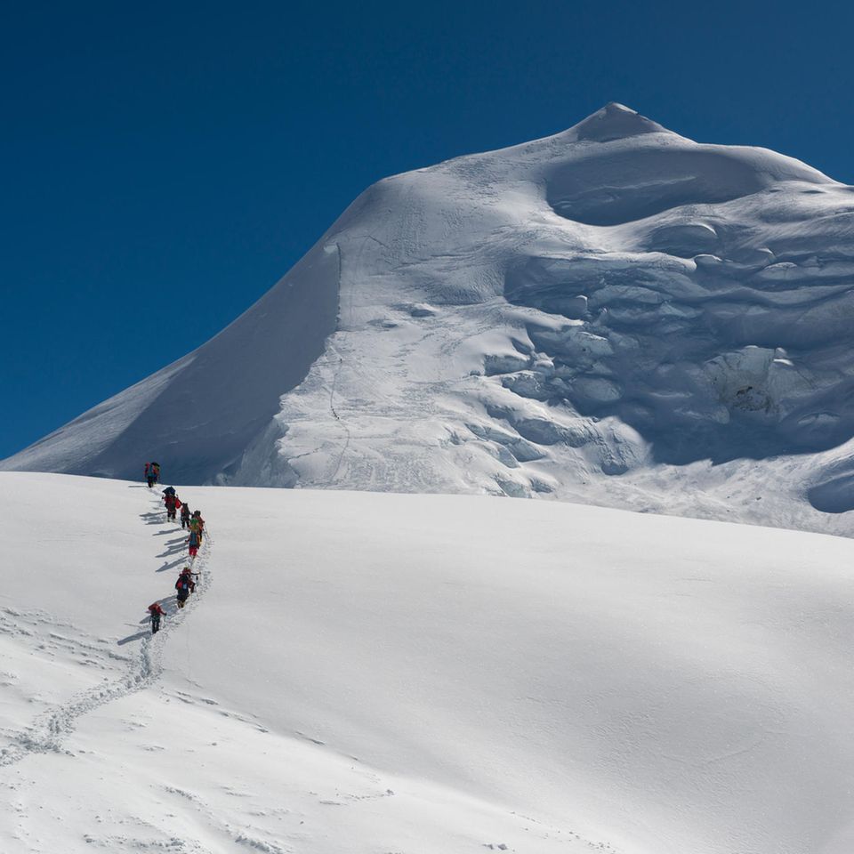 Menschen gehen einen Berg hinauf  Menschen gehen einen Berg hinauf