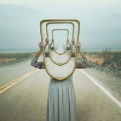 Frau hält Spiegel in die Höhe (Symbolbild für das Déjà-vu)