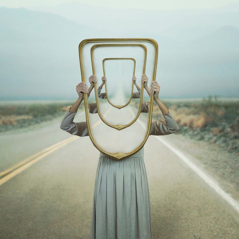 Frau hält Spiegel in die Höhe (Symbolbild für das Déjà-vu)