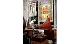 Grammophon mit Hundestatue, alte Filmplakate an der Wand.