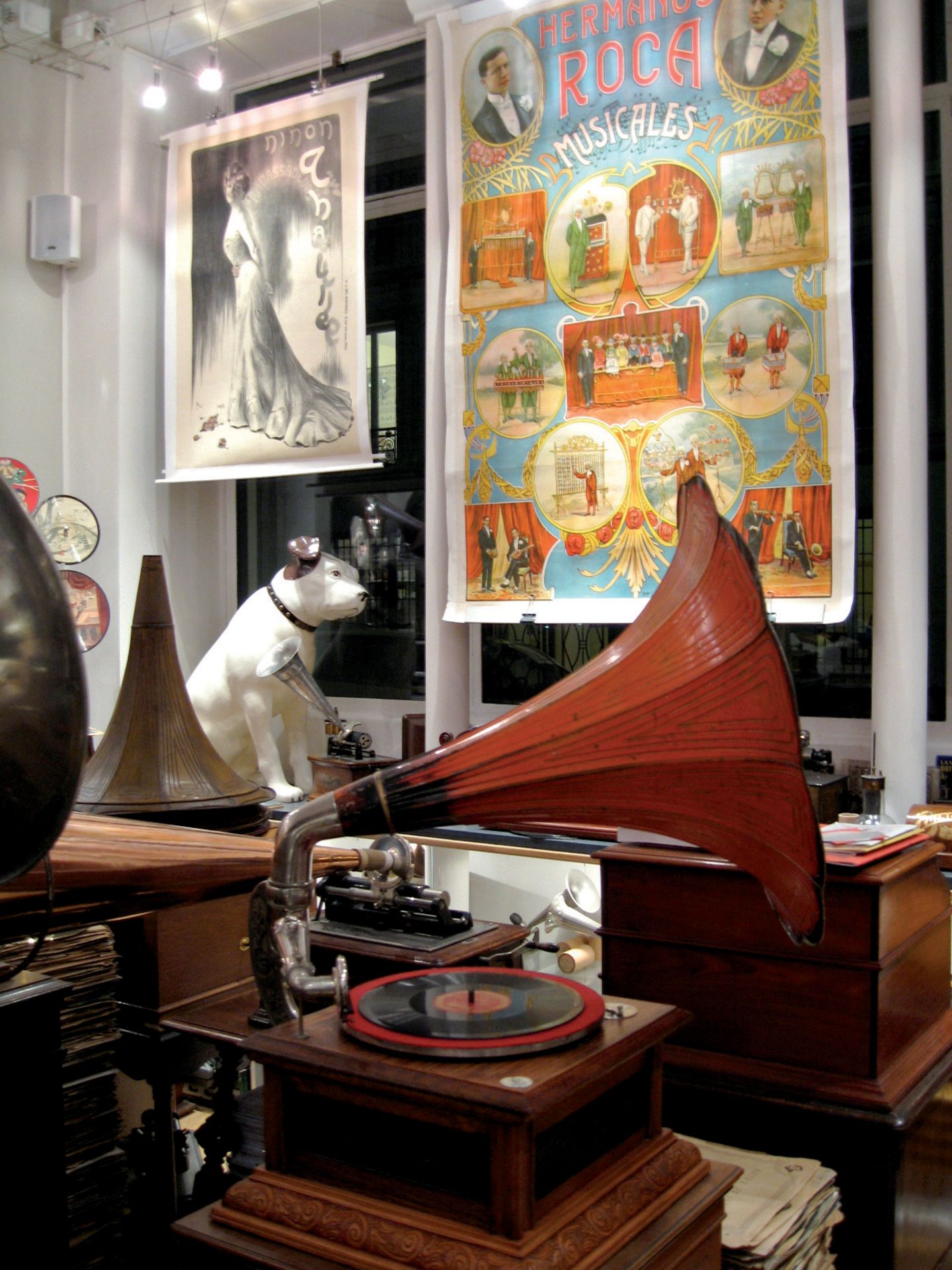 Grammophon mit Hundestatue, alte Filmplakate an der Wand.
