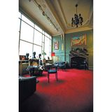 Stühle, Kamin, Büsten in einem sehr hellen, edlen Raum mit großem Fenster.