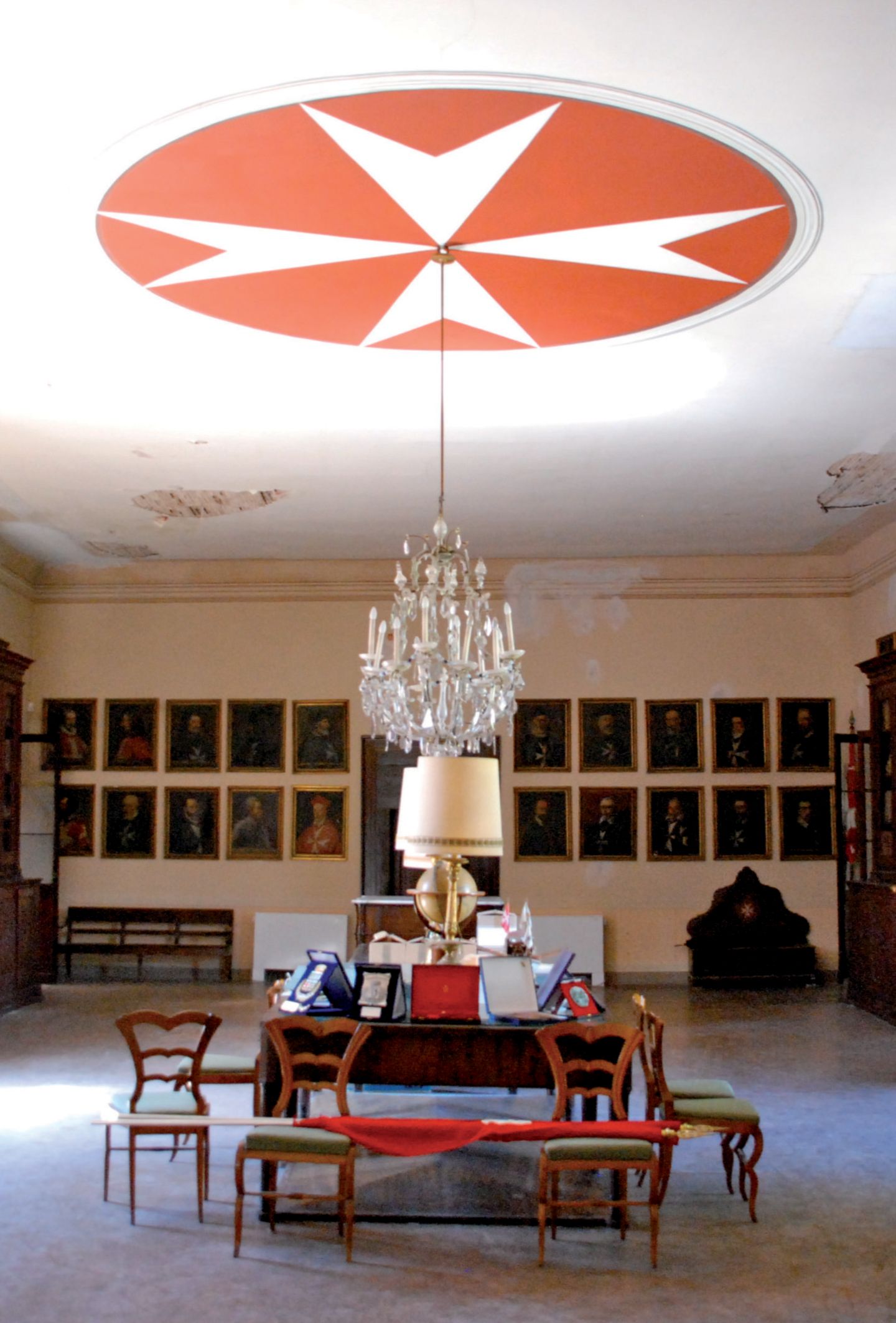 Die Sache mit dem Kreuz: der historische Komplex des Malteserordens Tisch und Stühle in einem Raum, an der Decke das Malteserkreuz