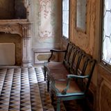 Mit Wandmalereien geschmücktes Foyer, Wartebank auf Steinfußboden