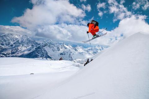 ein Mann springt mit Ski