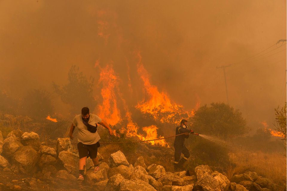 Die Klimakrise war in diesem Jahr überall auf der Welt zu spüren. Hier kämpft ein Feuerwehrmann im Dorf Hasia in der Nähe von Athen gegen einen Waldbrand