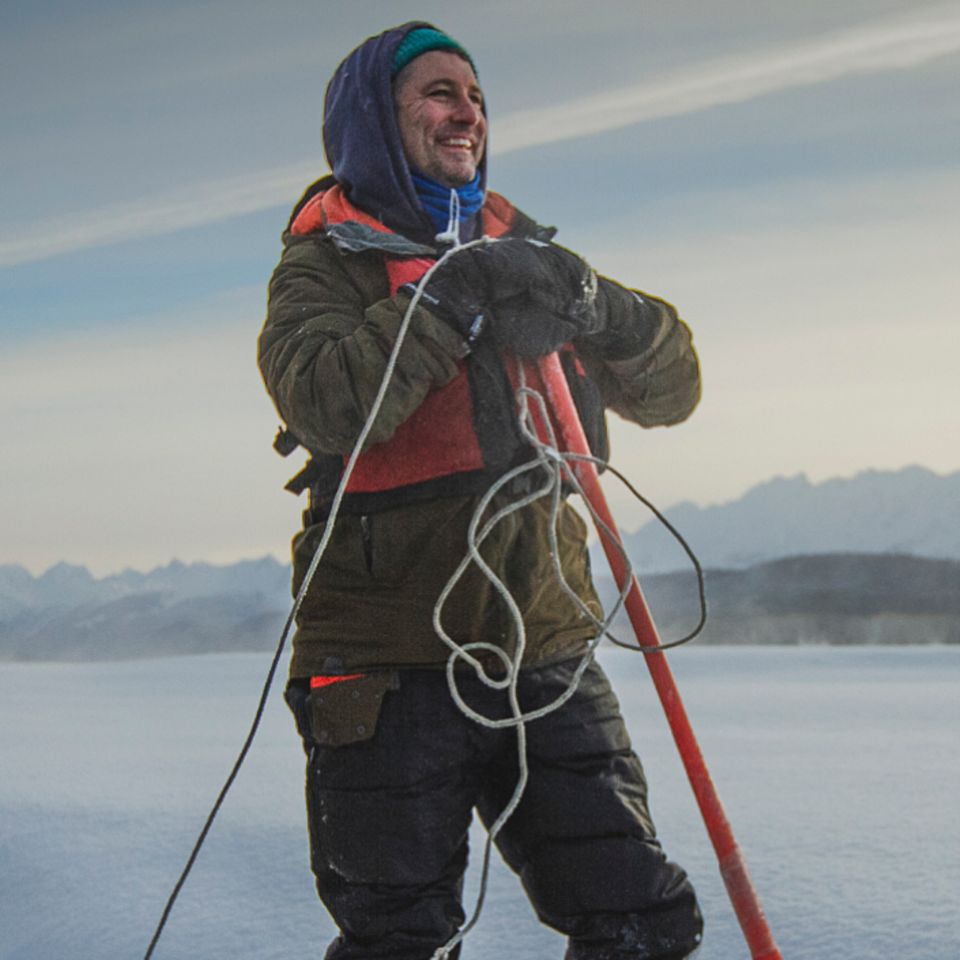Mann mit Paddel im Schnne, gegenüber ein Braunbär Mann mit Paddel im Schnne, gegenüber ein Braunbär