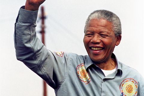 Nelson Mandela reckt die Faust in die Luft und lacht