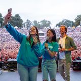 Zwei Repräsentantinnen und Tobi Krell machen ein Foto mit dem Publikum