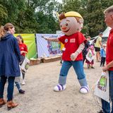 Maskottchen der Deutschen Bahn begrüßt Menschen.
