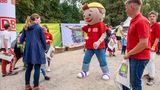 Maskottchen der Deutschen Bahn begrüßt Menschen.